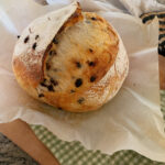 Chocolate chip sourdough on counter top with parchment paper and green towel