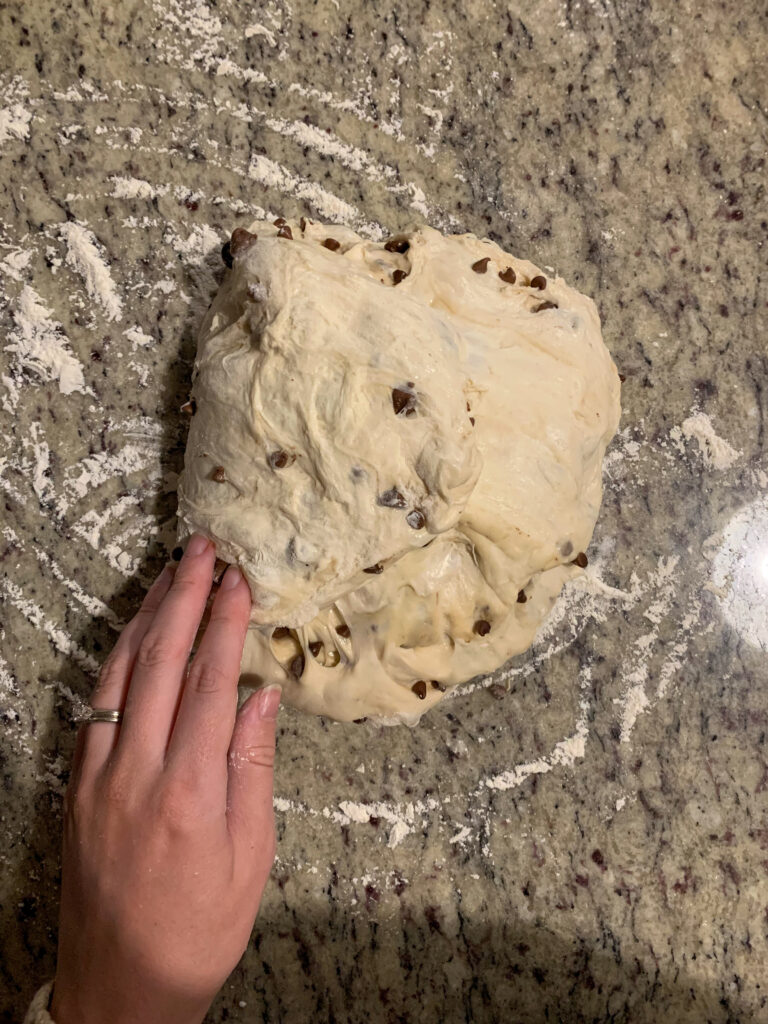 chocolate chip sourdough boule being shaped women's hand