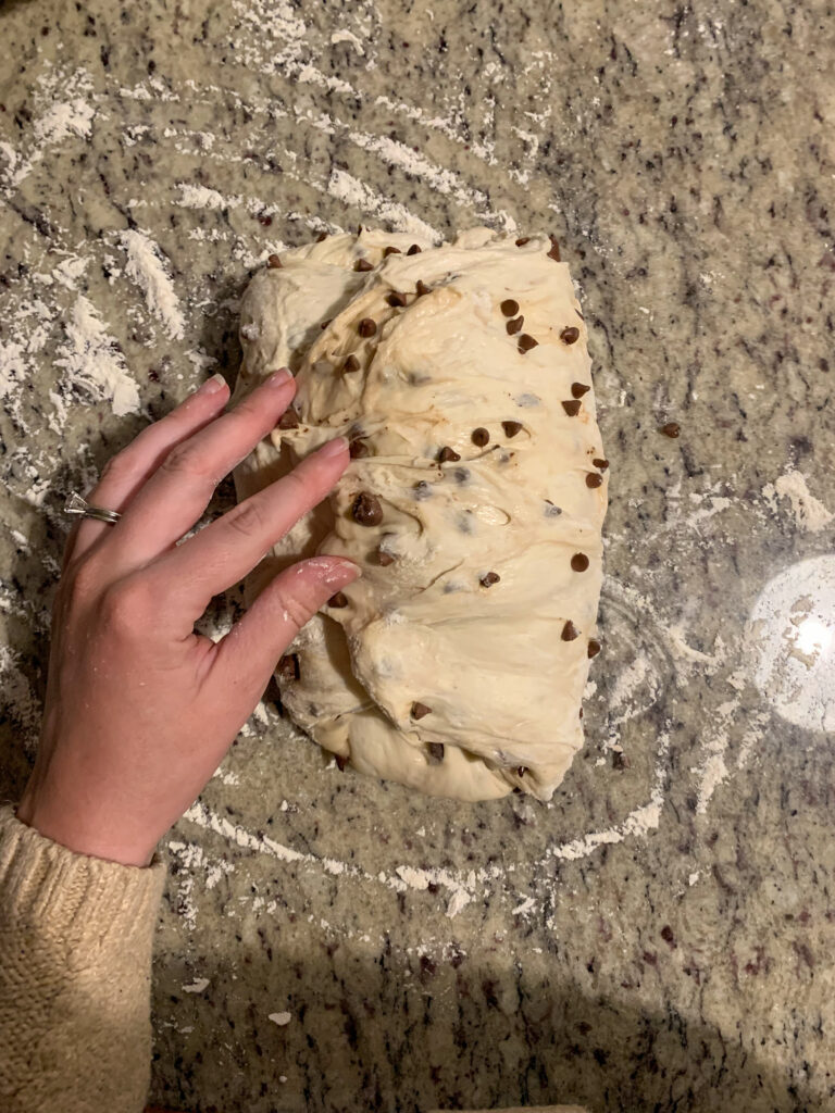 chocolate chip sourdough being shaped by womans hand