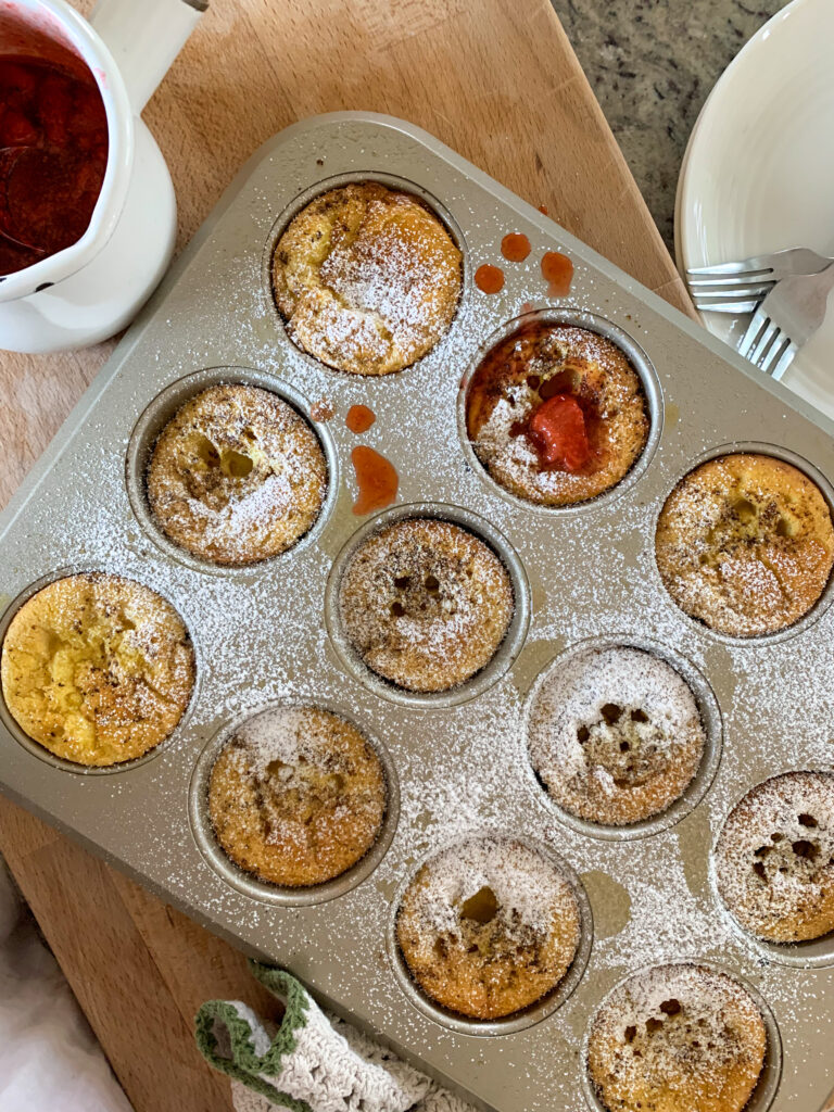 Dutch babies in muffin tin on wooden counter