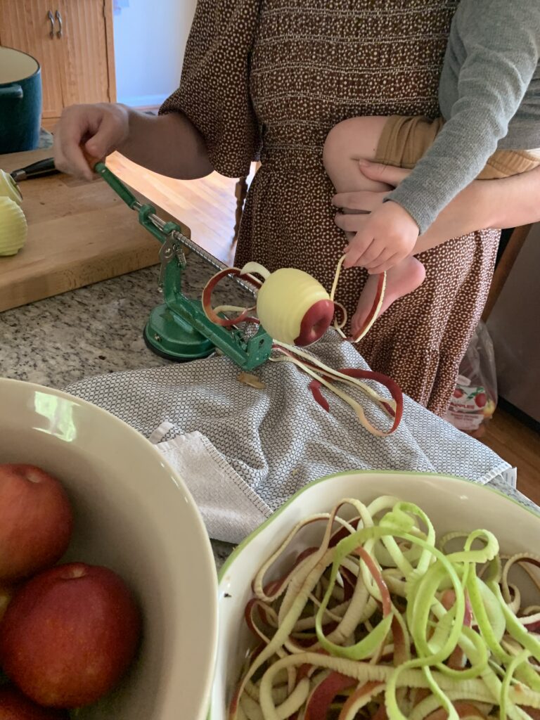 Peeling apples with baby on hip