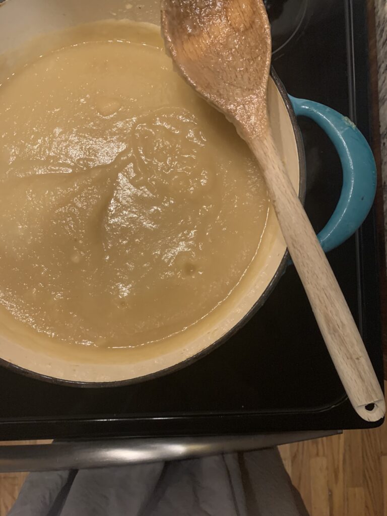 apple sauce in pot with wooden spoon